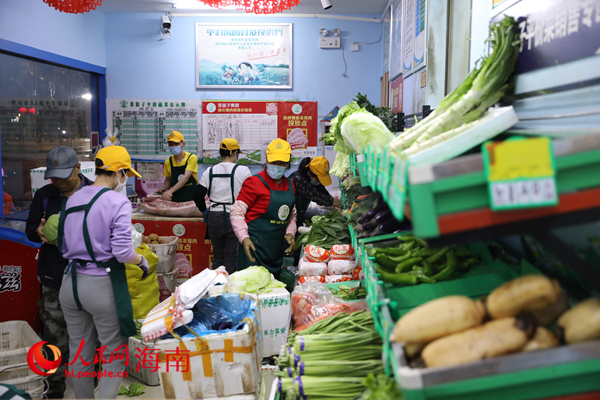 在海口市菜籃子平價(jià)超市，員工將運(yùn)進(jìn)來(lái)的蔬菜歸類(lèi)整理。人民網(wǎng) 孟凡盛攝