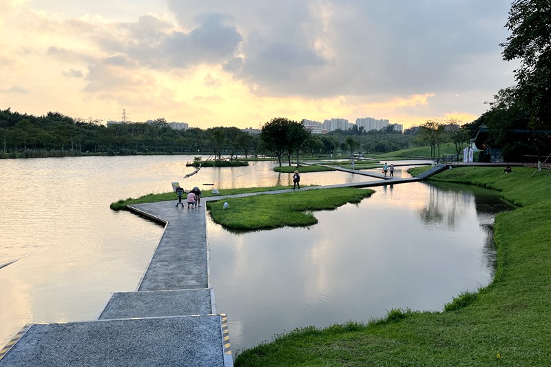 海口瓊山區美舍河鳳翔濕地公園一隅，市民在親水步道享受落日余暉下的天光水色。