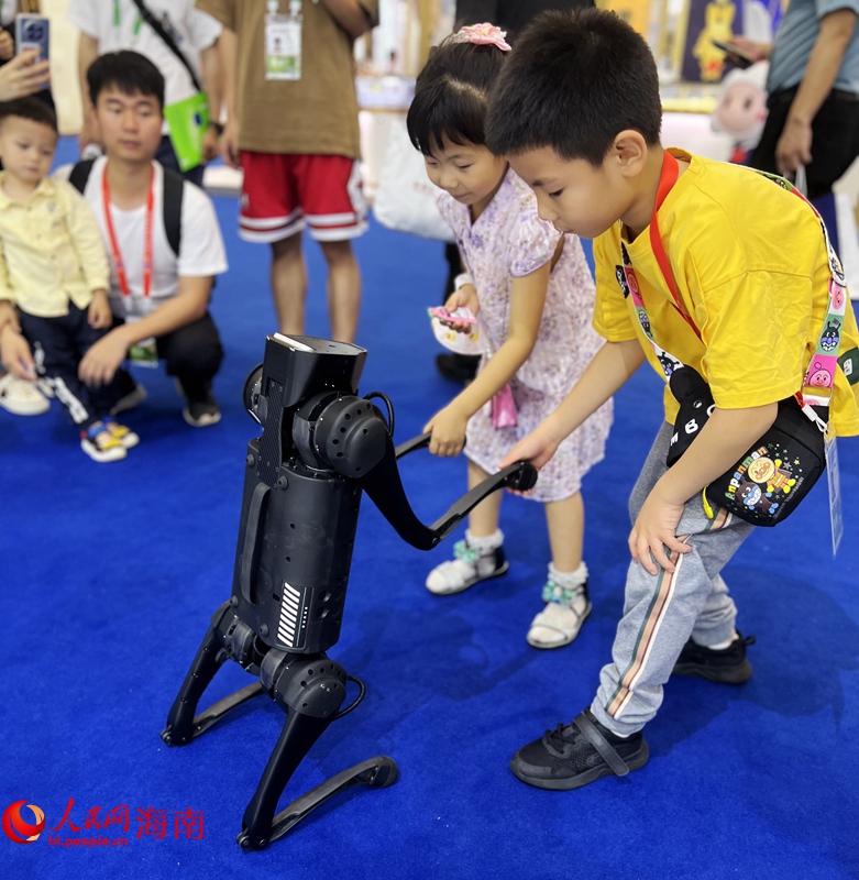 科大訊飛“AI四足機(jī)器狗”與小朋友握手互動(dòng)。人民網(wǎng) 蔣成柳攝