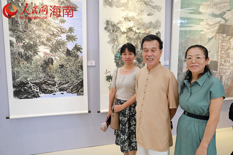 畫家陳兆堤（左二）與他的作品《黎家春風》。人民網(wǎng) 孟凡盛攝