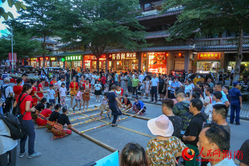 現(xiàn)場竹竿舞表演吸引眾多市民游客圍觀。人民網(wǎng) 牛良玉攝