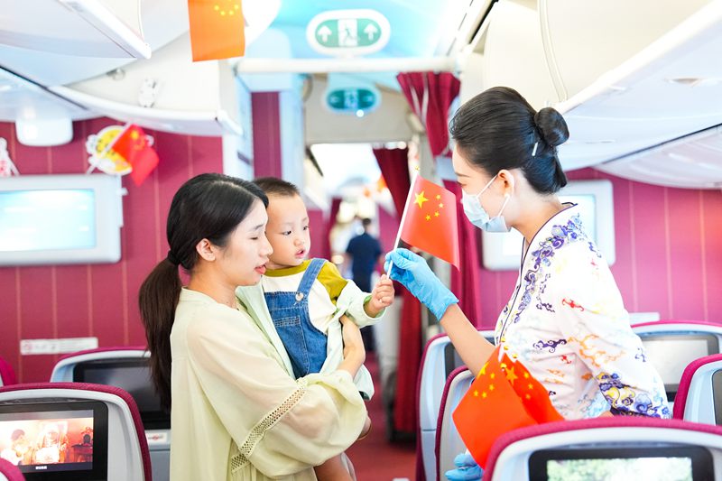 10月1日，海南航空乘務員為機上旅客發放小國旗。海南航空供圖.jpg