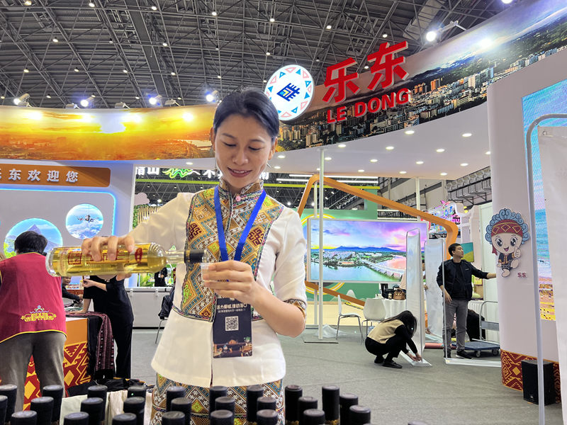 盧玲玉斟酒請(qǐng)參觀者品嘗。人民網(wǎng)記者李學(xué)山攝