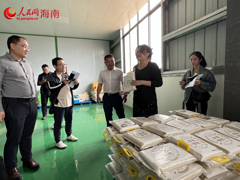 王婷（右二）介紹公坡香米種植和加工情況。人民網記者 李學山攝
