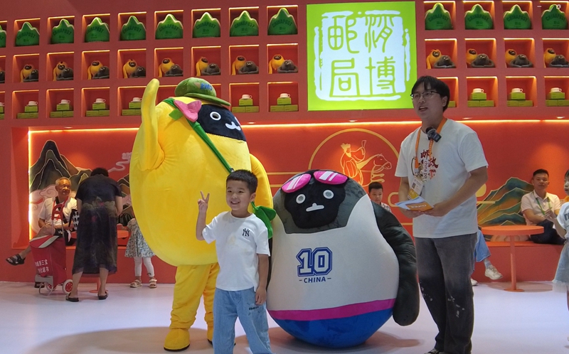 小朋友被吸引來(lái)和消博吉祥物合影（黃文燕攝）