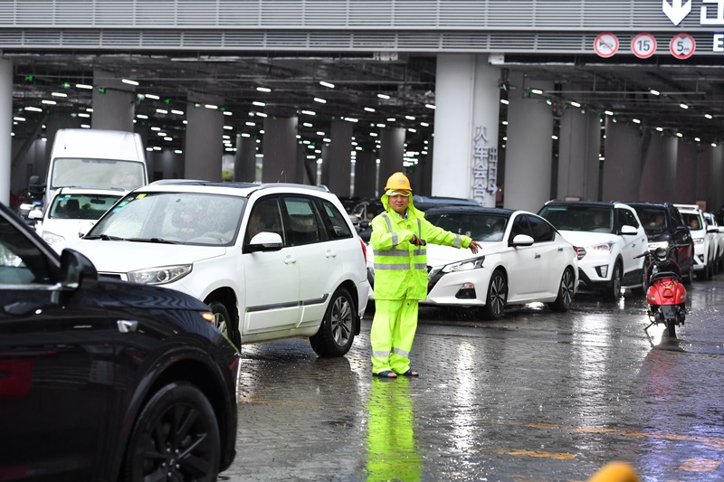 海口新海港工作人員雨中引導車輛。孫士杰攝