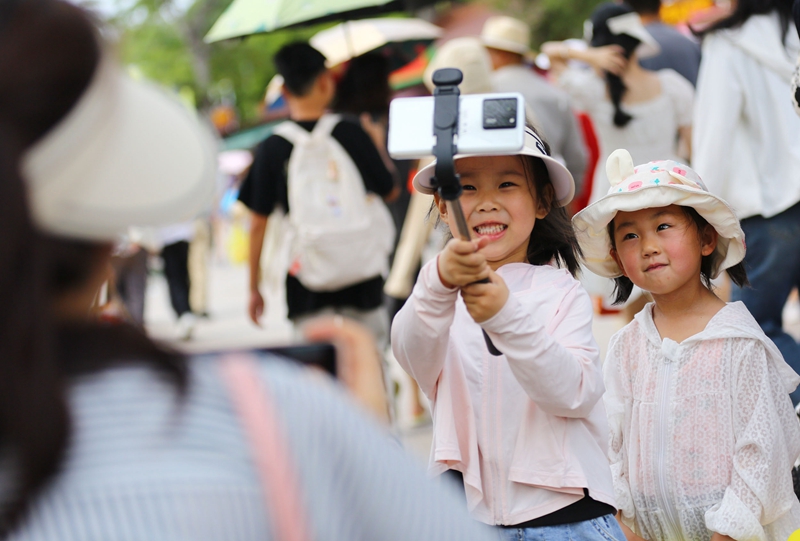5月3日，家長(zhǎng)帶著孩子在三亞南山文化旅游區(qū)游覽。