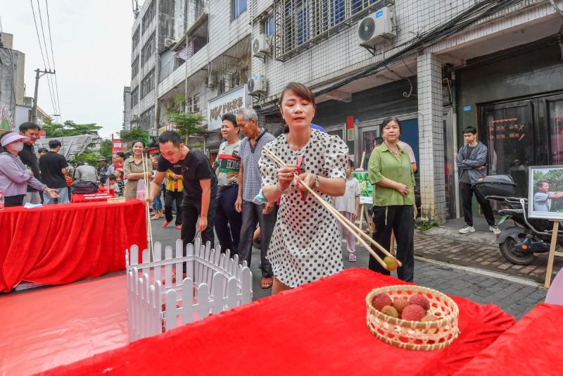 現場設置的“長筷夾荔枝”挑戰，緊張有趣。  主辦方供圖