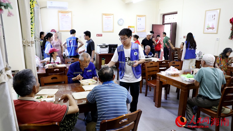 志愿者正在給用餐的老人盛湯。人民網(wǎng)記者 符武平攝