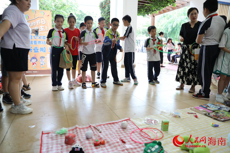 5月31日，在海口市第二十五小學公益跳蚤市場上，學生通過做游戲來贏得喜愛的物品。 人民網記者 孟凡盛攝