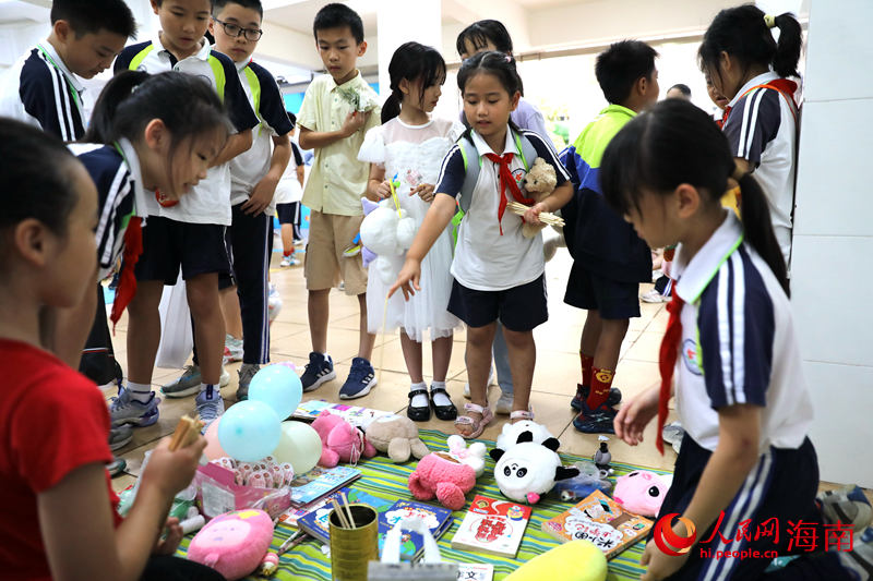 5月31日，在海口市第二十五小學公益跳蚤市場上，學生通過做游戲來贏得喜愛的物品。 人民網記者 孟凡盛攝