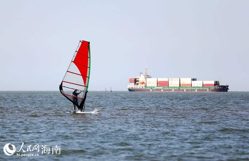 帆板與貨輪同框，形成一道靚麗的風景線。人民網記者 符武平攝