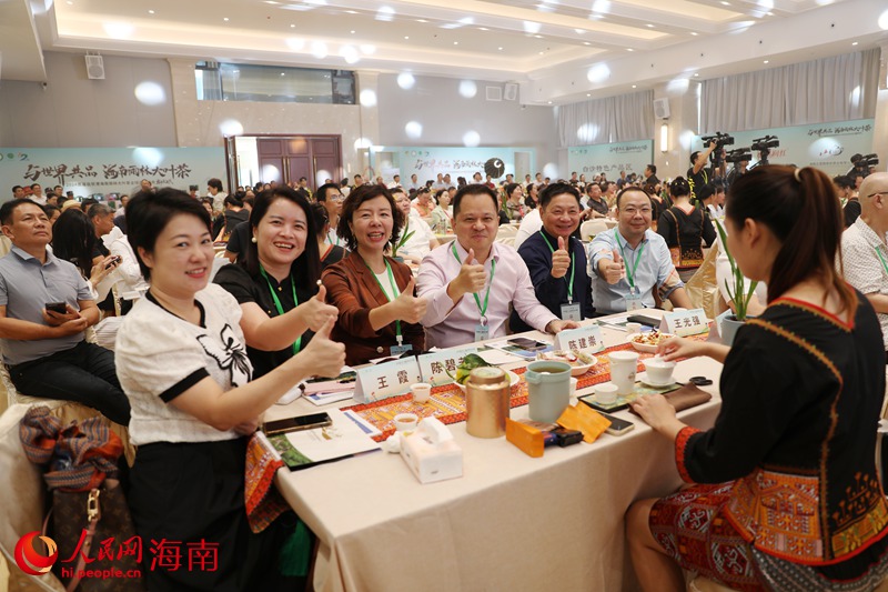 客商在現(xiàn)場為海南雨林大葉茶點(diǎn)贊。人民網(wǎng)記者 符武平攝