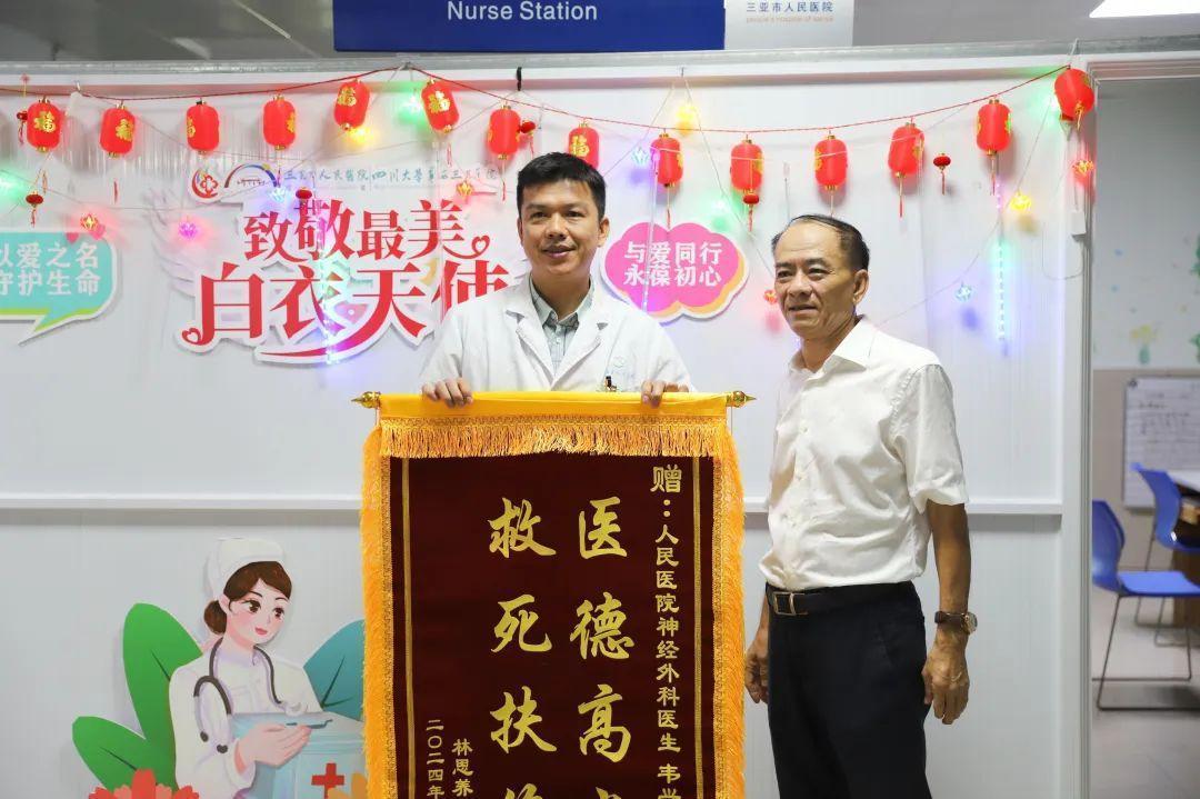 被救患者林思養（右）向三亞市人民醫院|四川大學華西三亞醫院神經外科主治醫師韋興澤（左）送上錦旗致謝。王妹琴 攝