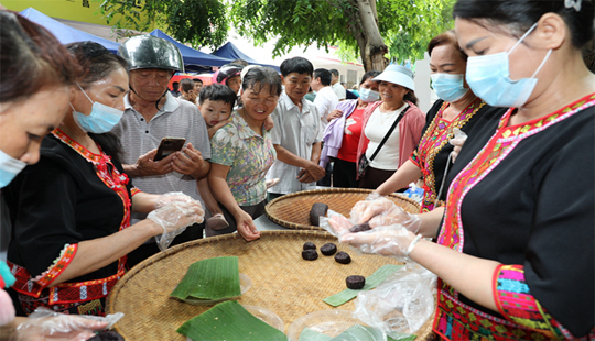 昌江“白石黑米”美食文化節(jié)現(xiàn)場(chǎng)，工作人員制作黑米糍粑
