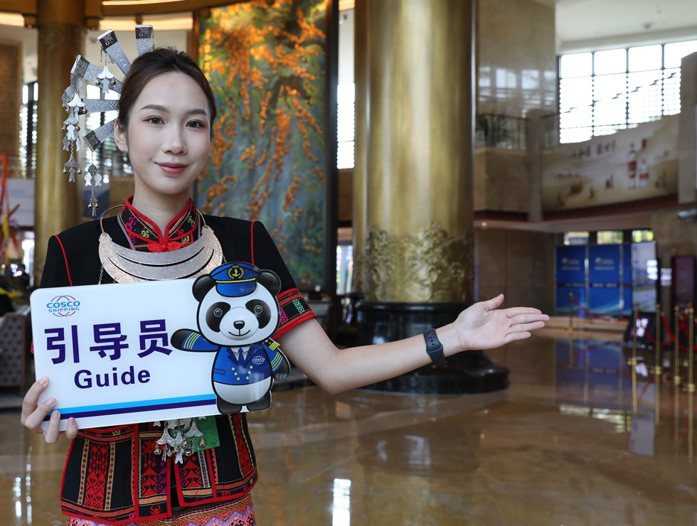 身穿黎族服裝的引導(dǎo)員在論壇現(xiàn)場給來賓做引導(dǎo)