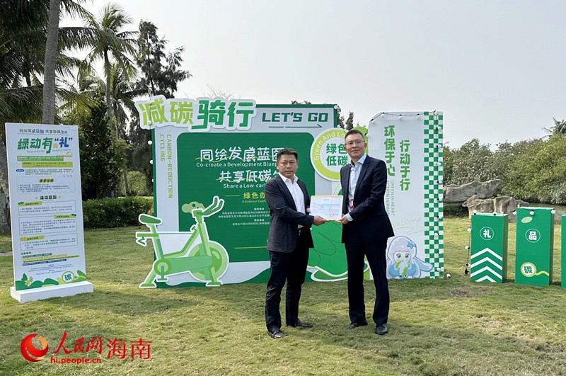 中共海南省委外事工作委員會辦公室副主任王磊向瓊海市人民政府副市長符展授予“碳匯捐贈感謝狀”。人民網記者 符武平攝