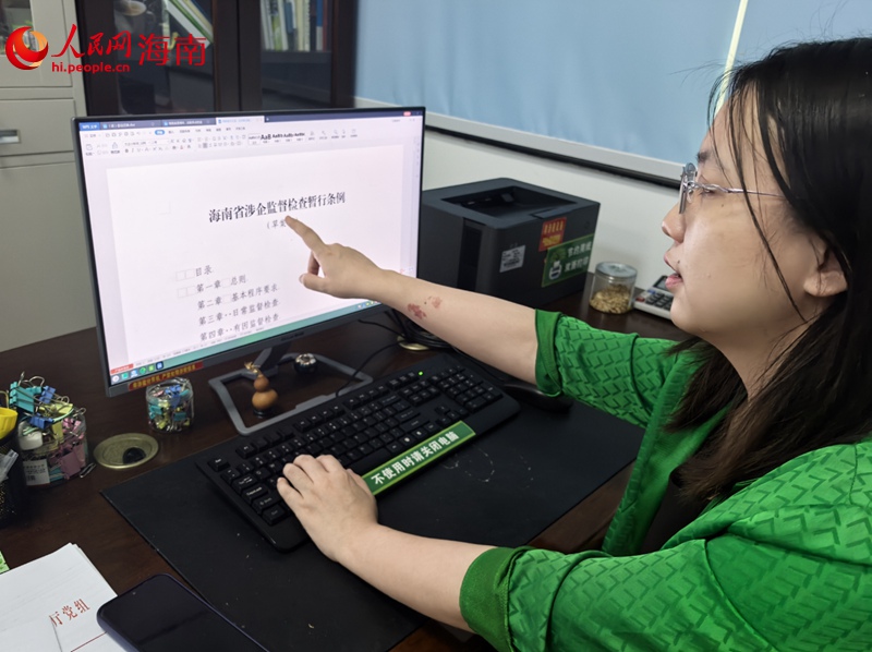馮譯向記者展示海南優化營商環境的最新成果。人民網記者 毛雷攝